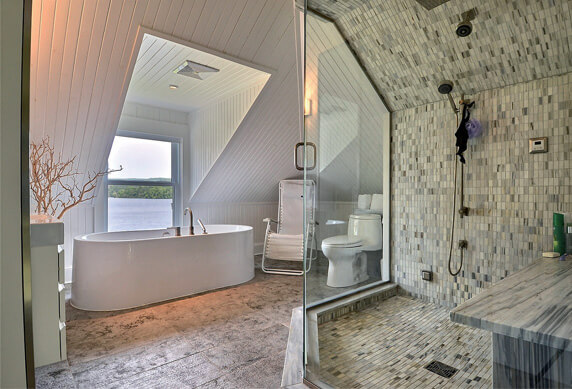 Salle de bain avec baignoire et douche en céramique et vitré, vue sur l'eau